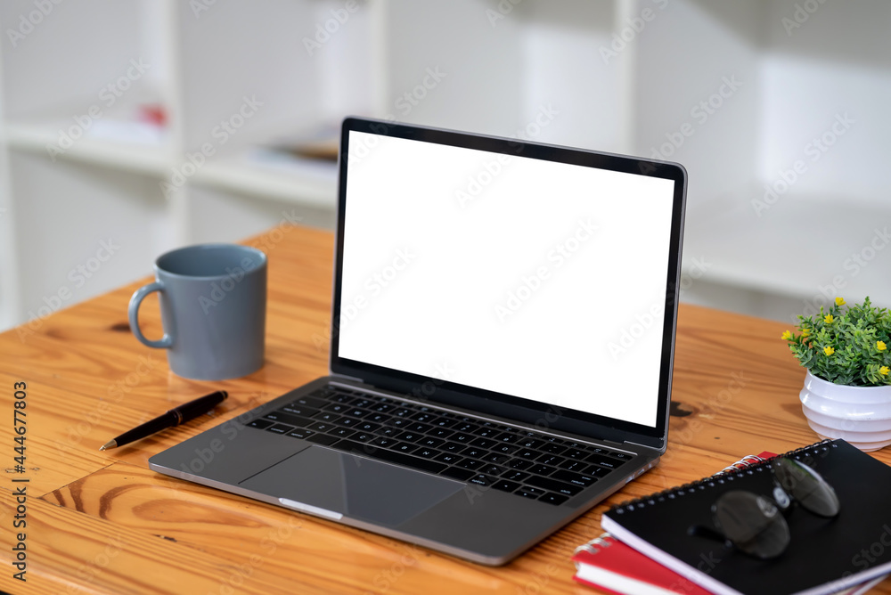 Workspace blank white screen laptop  placed at office desk. Mock up.