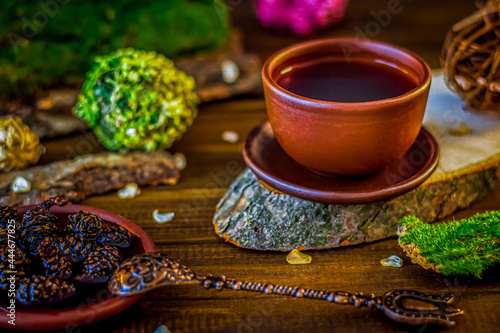 tea in a clay cup a beautiful spoon in oriental style on a wooden background photo