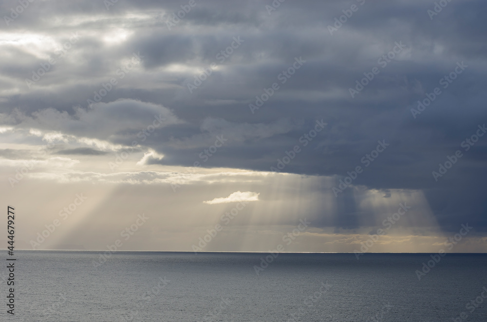 Sunbeams and storm clouds over the ocean off Bruny Island, Tasmania