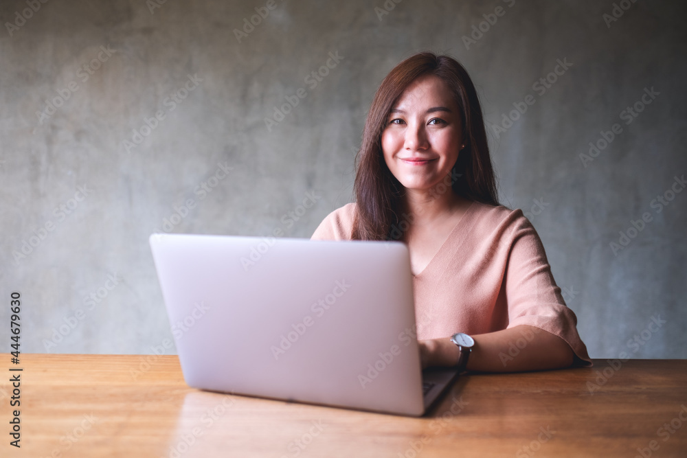 Portrait image of a beautiful young woman using and working on laptop computer Portrait image of a beautiful young woman using and working on laptop computer