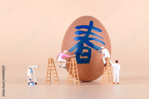 The painter paints a spring character on the egg photo