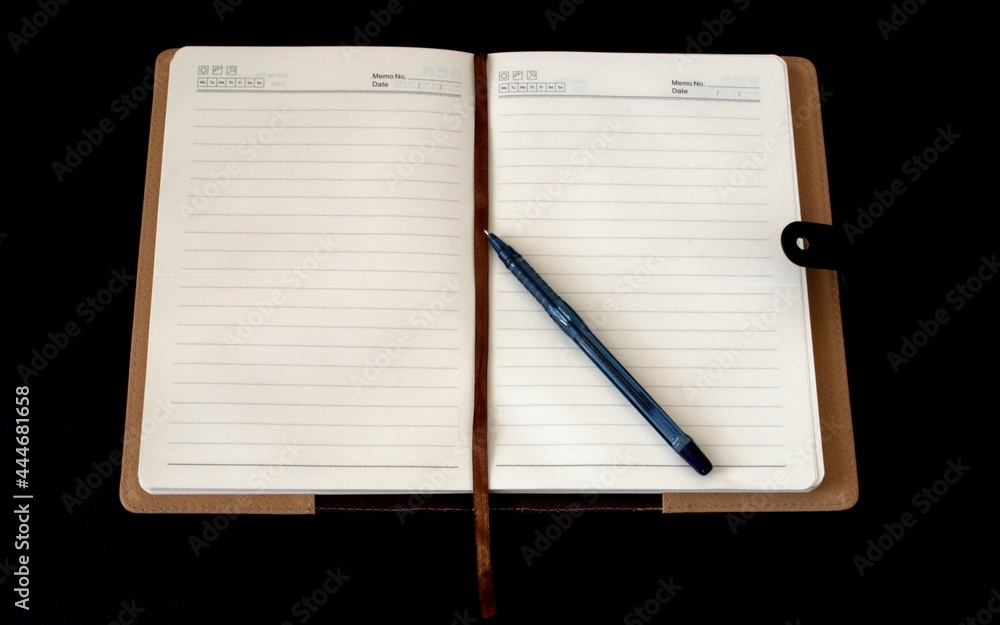 Notepad for notes and a pen on a black background Notepad for notes and a pen on a black background