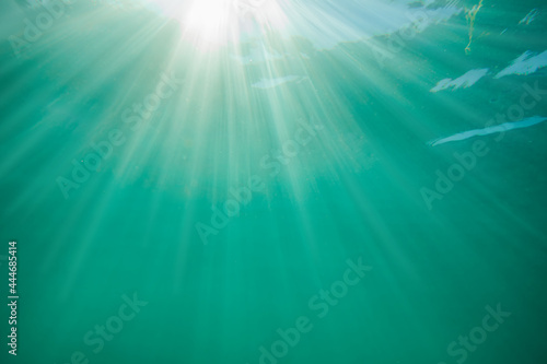 Underwater ocean background and shining sun rays.