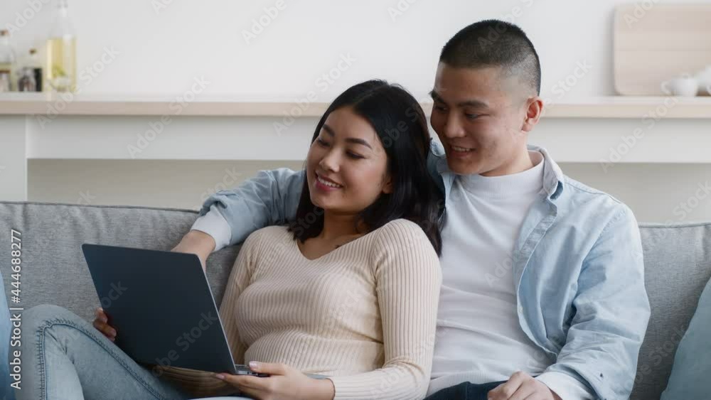 Happy Asian Couple Watching Movie On Laptop Relaxing At Home Happy Asian Couple Watching Movie On Laptop Relaxing At Home