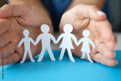 Women hands protect a family with children from paper
