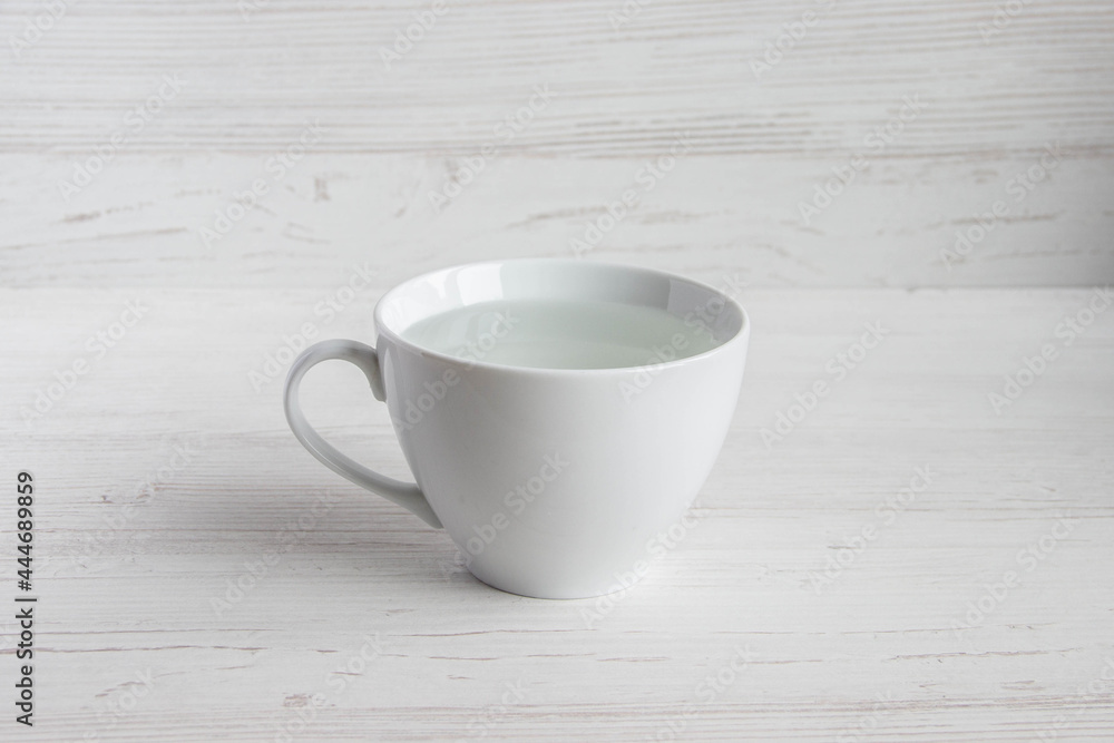 transparent clean water in a white cup on a wooden background transparent clean water in a white cup on a wooden background