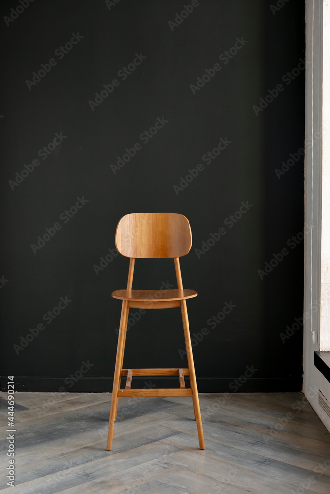 wooden bar stool in the interior against the background of a dark wall wooden bar stool in the interior against the background of a dark wall