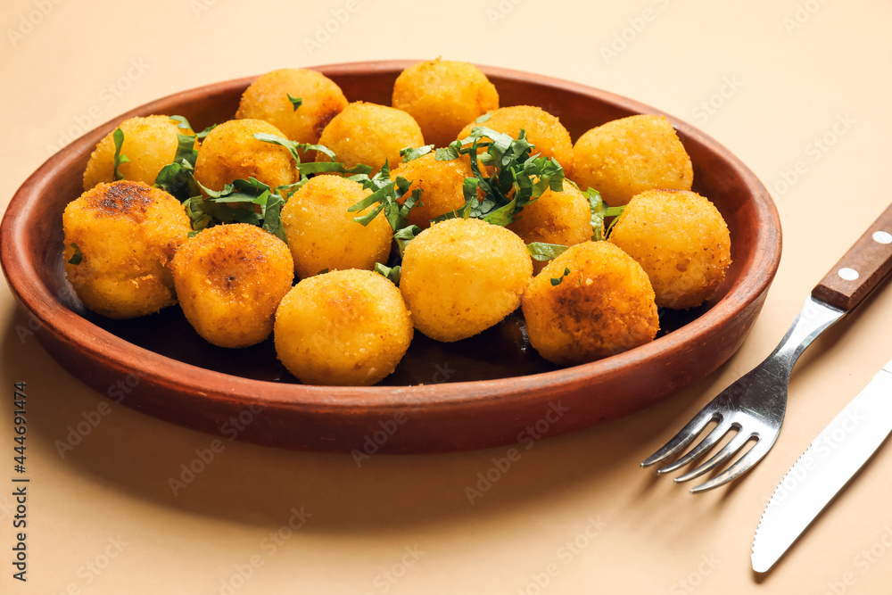 Plate with fried potato balls on color background Plate with fried potato balls on color background