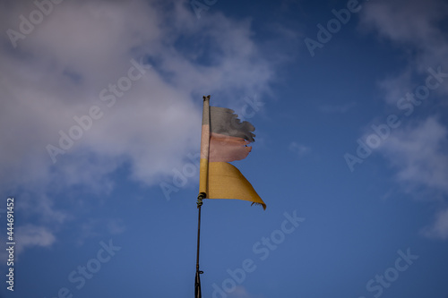 A torn German flag with clouds in the background, seen near Klein Kubitz, Mecklenburg-Western Pomerania, Germany