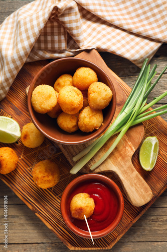 Composition with fried potato balls on wooden background