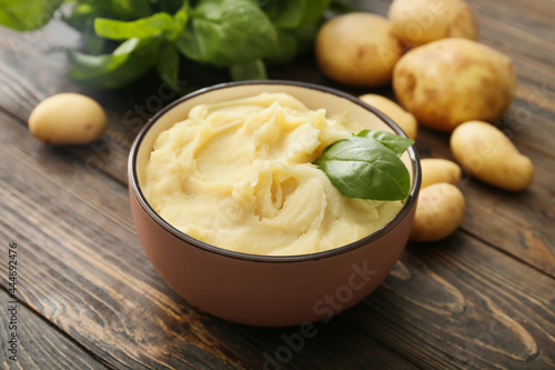 Bowl with tasty mashed potatoes on wooden background