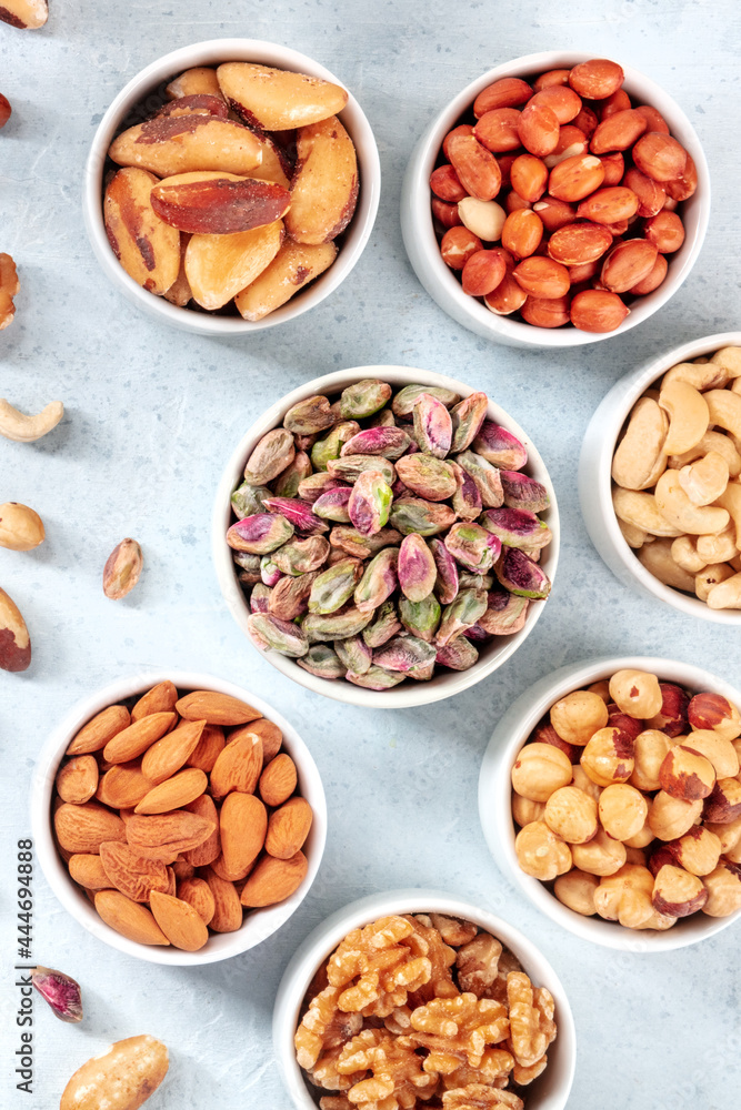 Nuts in bowls, shot from the top on a slate background. Pistachios, almonds, walnuts and other nuts Nuts in bowls, shot from the top on a slate background. Pistachios, almonds, walnuts and other nuts
