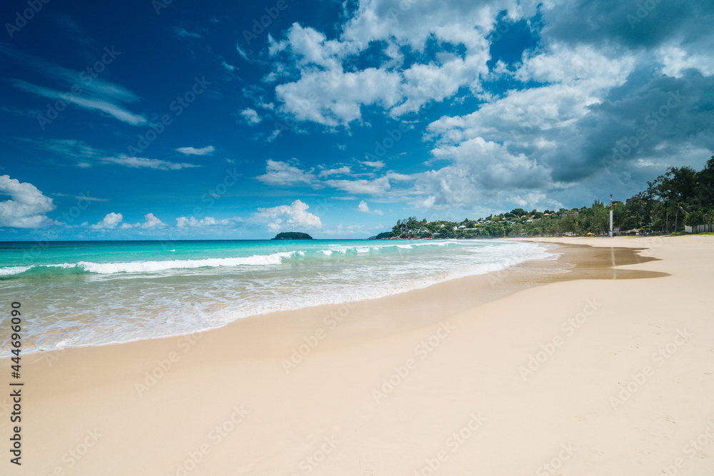 Beautiful tropical beach with white sand, palm trees, turquoise ocean against cloudy sky on summer day. Perfect landscape background for relaxing vacation. Summer vacation and nature travel adventure 