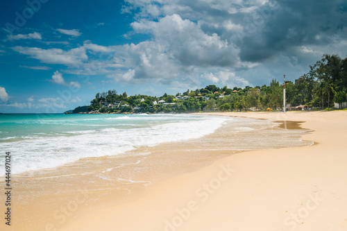 Fototapeta Naklejka Na Ścianę i Meble -  tropical beach landscape with trees on the shore of the beach and cloudy sky. Summer vacation and nature travel adventure concept.. Summer composition.