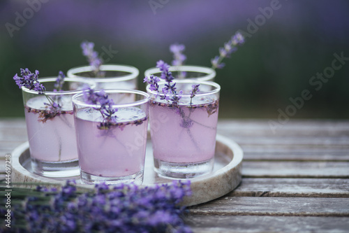 Fresh lavender lemonade on marble tray standing on wooden table.