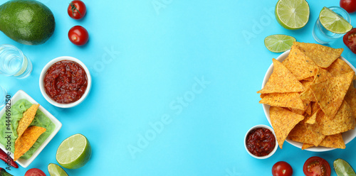 Party concept with tequila, guacamole and chips on blue background