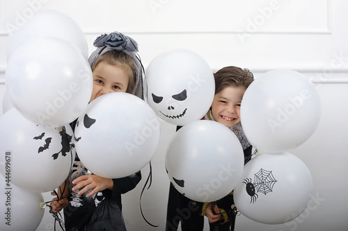 Happy family with children in costumes of witch and vampire in a house in holiday Halloween