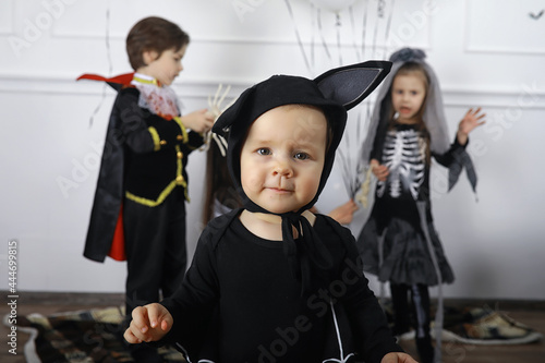 Happy family with children in costumes of witch and vampire in a house in holiday Halloween