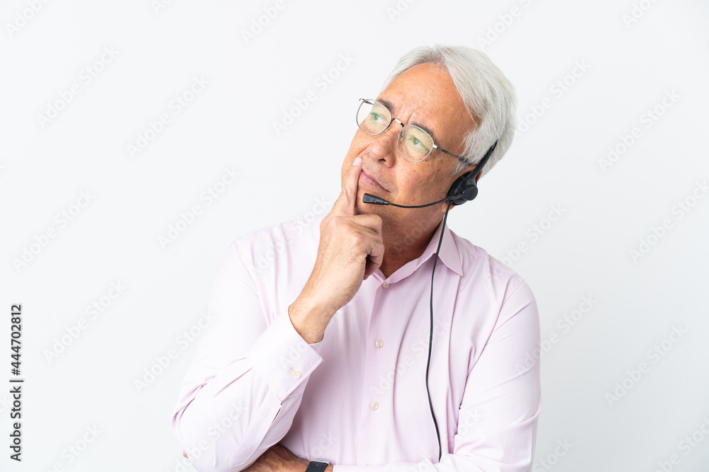 Telemarketer Middle age man working with a headset isolated on white background having doubts while looking up Telemarketer Middle age man working with a headset isolated on white background having doubts while looking up