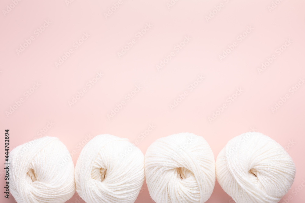 White clews of wool on a pink background. Place for your text. Top view White clews of wool on a pink background. Place for your text. Top view