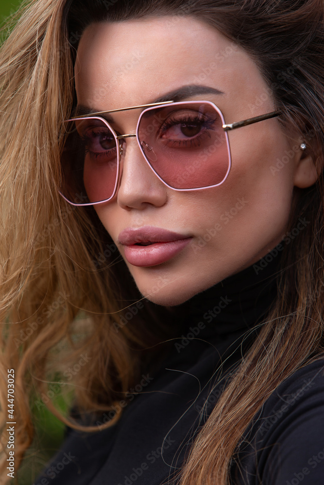 Young girl in sunglasses and a black blouse. Close-up portrait. Young girl in sunglasses and a black blouse. Close-up portrait.