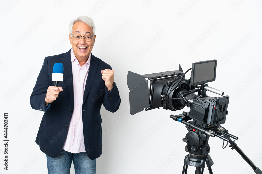 Reporter Middle age Brazilian man holding a microphone and reporting news isolated on white background celebrating a victory in winner position