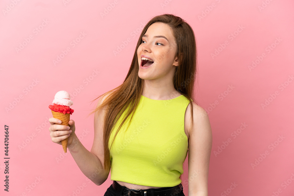 Teenager girl with a cornet ice cream over isolated pink background laughing in lateral position Teenager girl with a cornet ice cream over isolated pink background laughing in lateral position