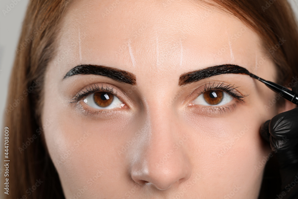 Naklejka premium Beautician applying tint during eyebrows correction procedure, closeup