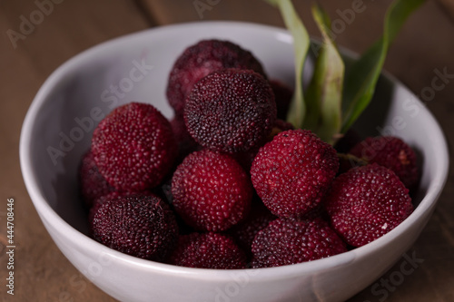 a bowl of bayberry fruit on a wooden plank photo