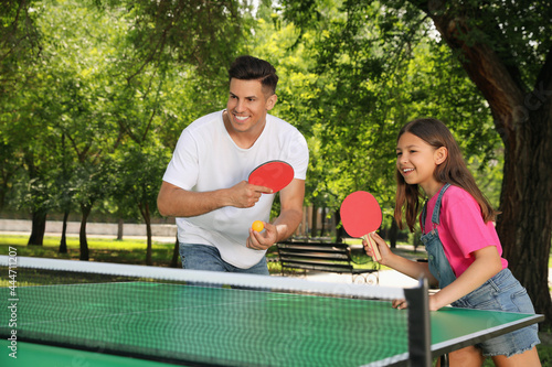 Happy man with his daughter playing ping pong in park © New Africa
