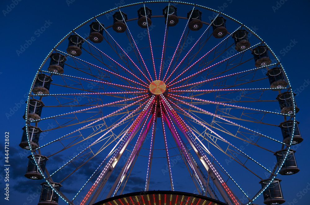 High Ferris Wheel against dark night sky in our summer vacation at Adriatic seaside. Amusement park ride. Holidays concept.