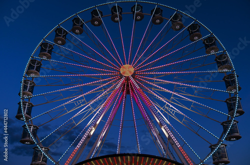 High Ferris Wheel against dark night sky in our summer vacation at Adriatic seaside. Amusement park ride. Holidays concept.
