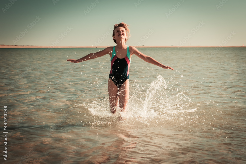 Little girl playing on beautiful ocean beach