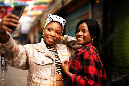 Portrait of a happy smiling female friends. Beautiful african woman taking selfie photo