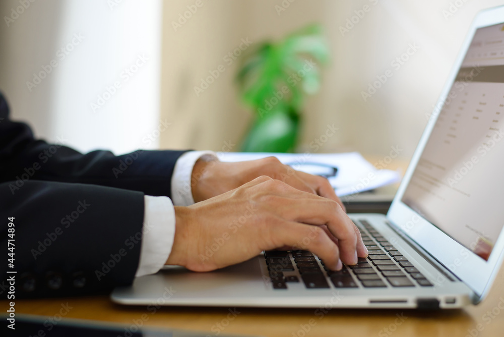 Businessman wearing suit hands typing on laptop keyboard and surfing the internet, online, working, business and technology, internet network communication on office desk at home. Businessman wearing suit hands typing on laptop keyboard and surfing the internet, online, working, business and technology, internet network communication on office desk at home.