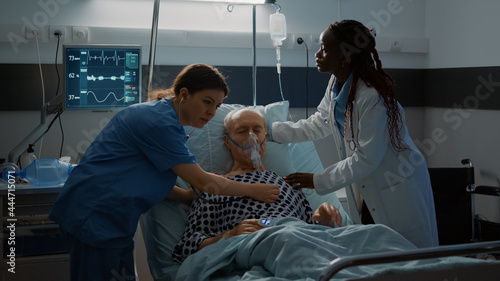 Φωτογραφία Patient with breathing problems fainting in hospital ward bed at modern equipment medical facility