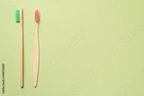 Bamboo toothbrush on a green background.