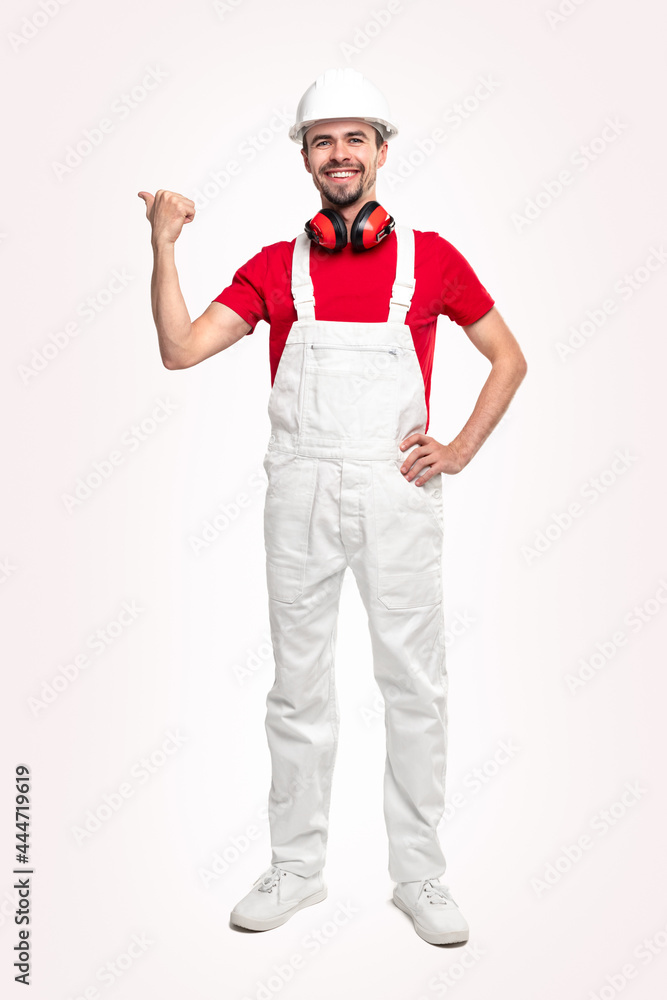 Friendly repairman in workwear pointing away Friendly repairman in workwear pointing away