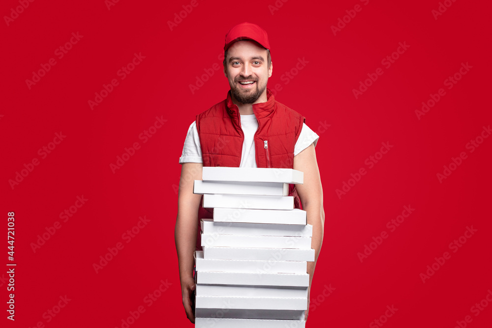 Cheerful delivery man with pizza boxes on red background Cheerful delivery man with pizza boxes on red background
