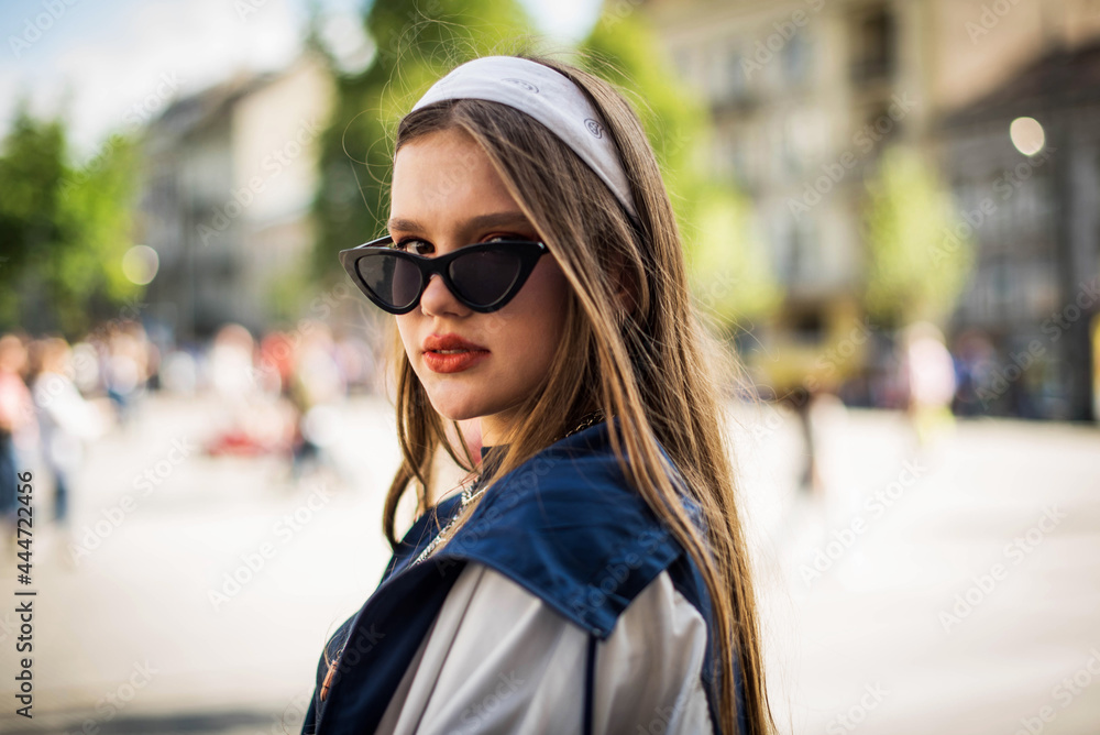 Beautiful country girl in 90s style. Back in time 90s 80s. Stylish girl in retro colourful vintage coat. dressed in street style clothes with chains around neck for a walk. Youth and lifestyle concept Beautiful country girl in 90s style. Back in time 90s 80s. Stylish girl in retro colourful vintage coat. dressed in street style clothes with chains around neck for a walk. Youth and lifestyle concept