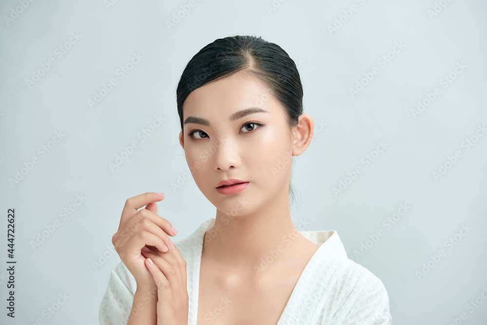 Youthful bright skin pretty Asian woman with hand touching face on white background for beauty concepts Youthful bright skin pretty Asian woman with hand touching face on white background for beauty concepts