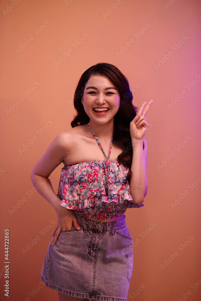 Closeup shoot of young girl with beautiful makeup looking at camera with neon red background Closeup shoot of young girl with beautiful makeup looking at camera with neon red background