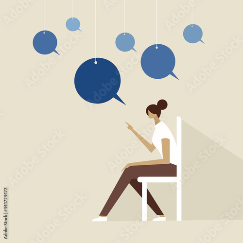 A person siting on chair with speech bubbles hanging on strings