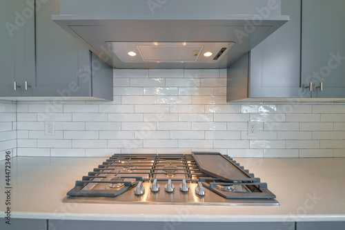 Fényképezés Cooktop with burners fixed on the kitchen countertop of home with exhaust hood