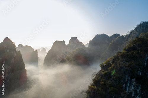 Aerial of beautiful sunrise over foggy  karst mountain peak landscape photo