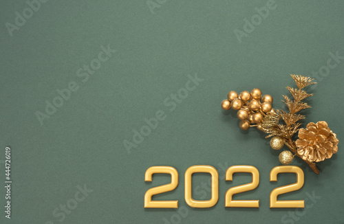 2022 New Year gold numbers and decor with copy space on dark green background