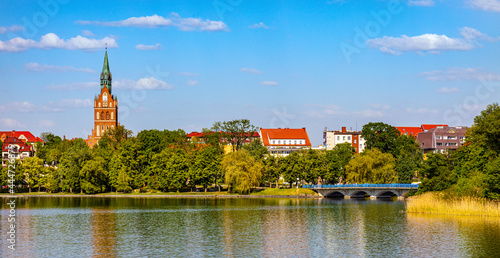 Fototapeta Naklejka Na Ścianę i Meble -  Panorama of Elk historic city center with Holiest Heart of Jesus neo-gothic church tower on shore of Jezioro Elckie lake in Masuria region in Poland