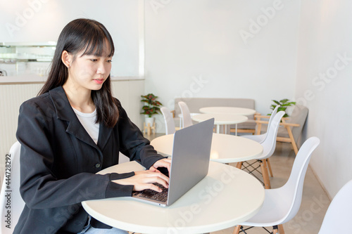 Asian woman using laptop in coffee shop