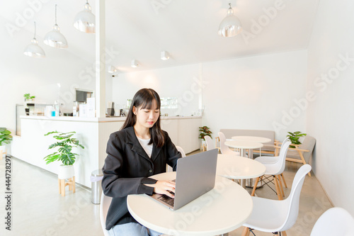 Asian woman using laptop in coffee shop