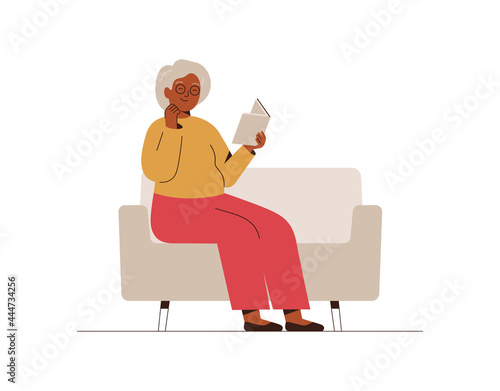 Senior woman sits on the couch and reads the book with interest. Grandmother spends time at home with a book. Leisure and relax concept. Vector illustration